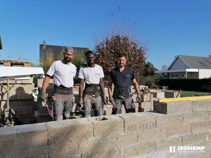 maçons heureux de poser des blocs de chanvre